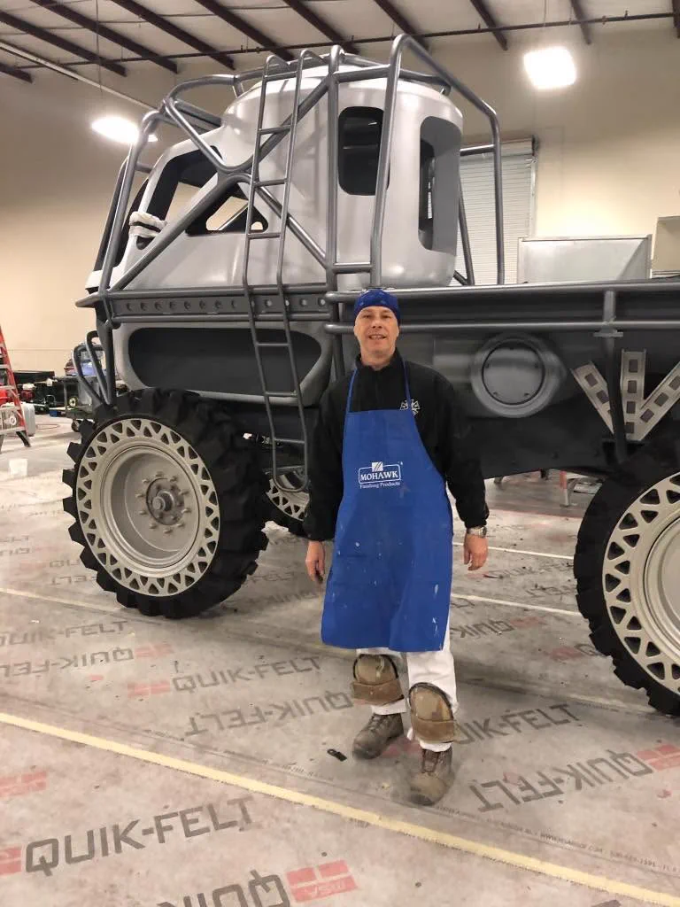 Dwayne Sisson standing beside a custom-painted specialty vehicle