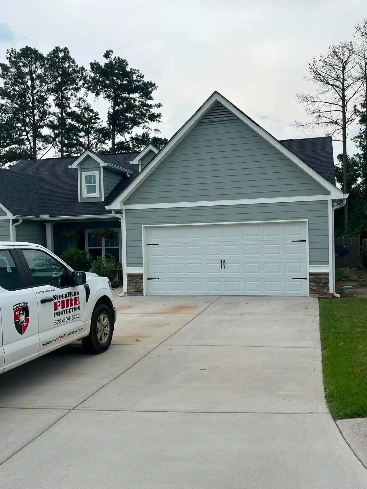 Finished garage elevation with blue-gray siding and bright white trim