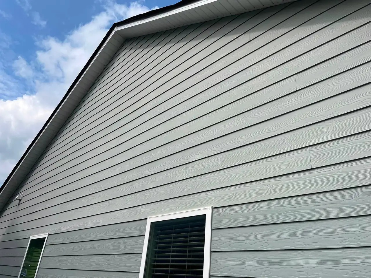 Detailed view of smooth blue-gray siding coverage and white eaves