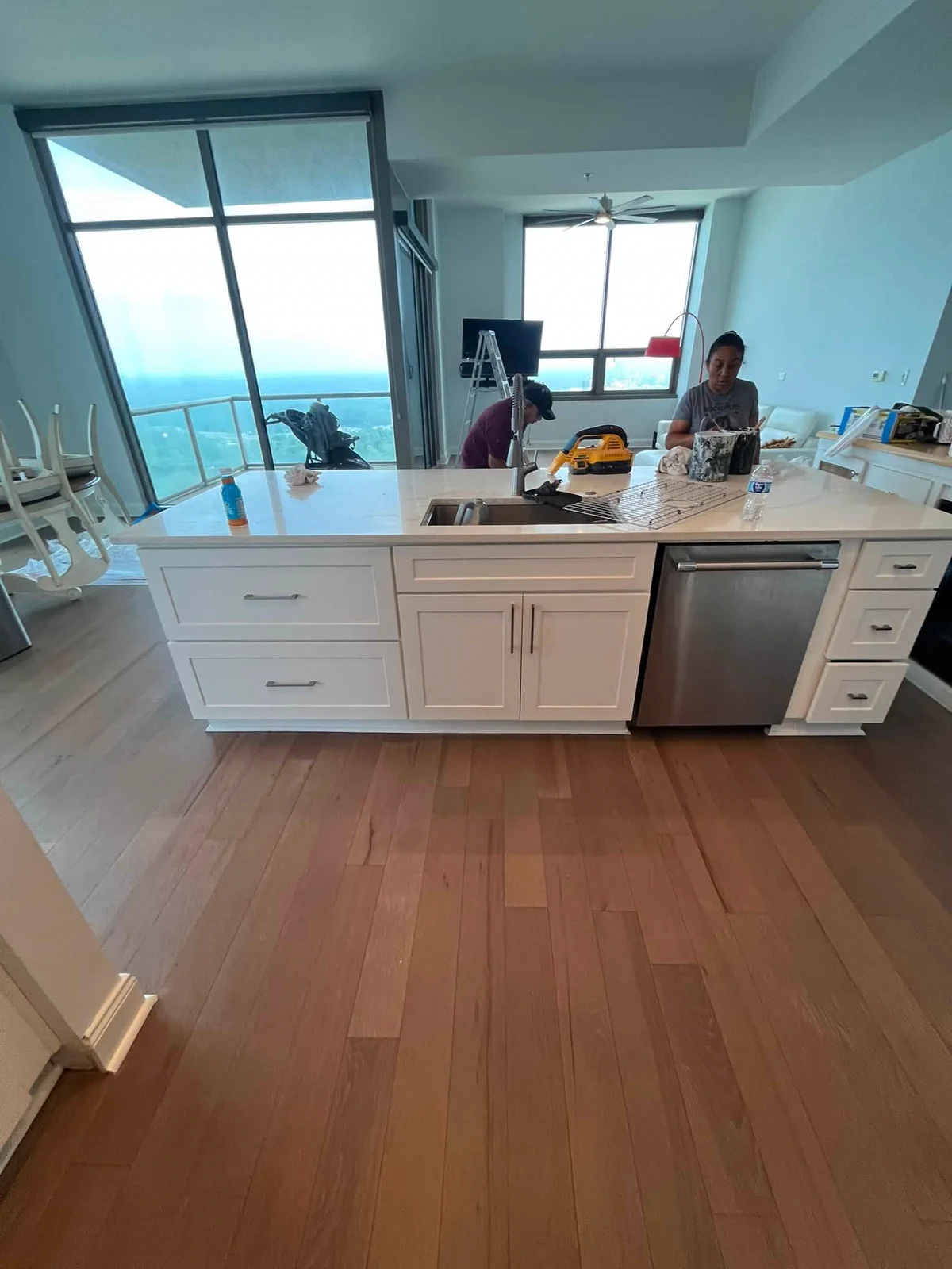 Finished high-rise kitchen with bright white cabinetry and warm wood flooring