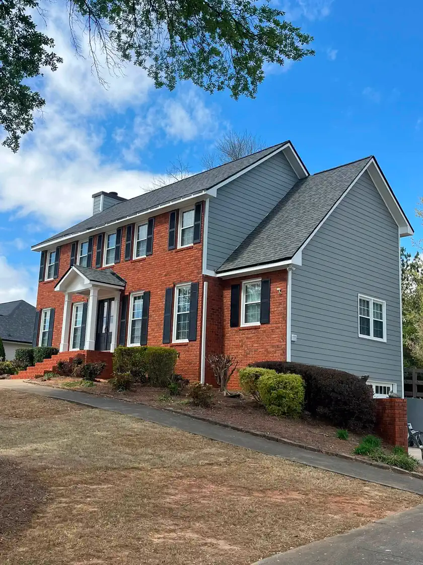 Red brick home after the siding was repainted blue-gray