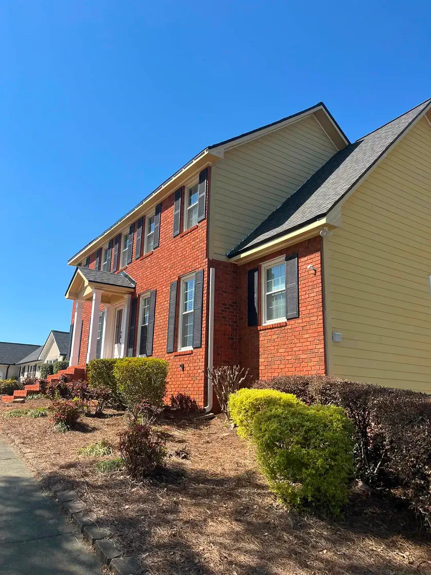 Red brick home with yellow siding before the exterior color change