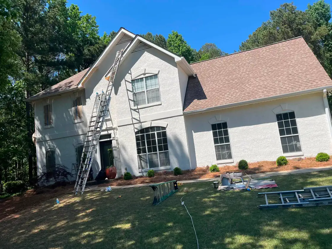White brick home exterior during upper-story painting work